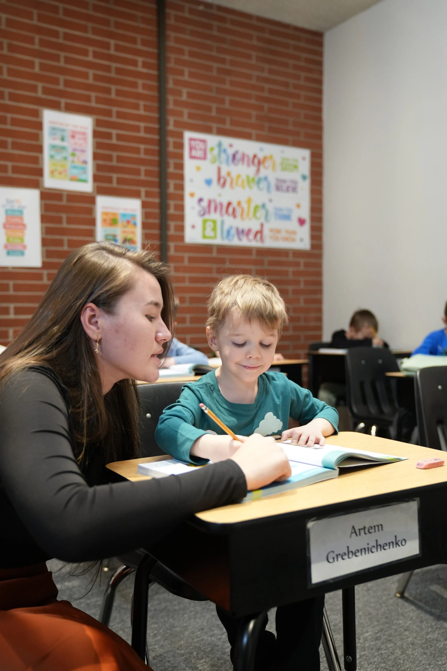 Teacher helping a student with a workbook at Smart Generation